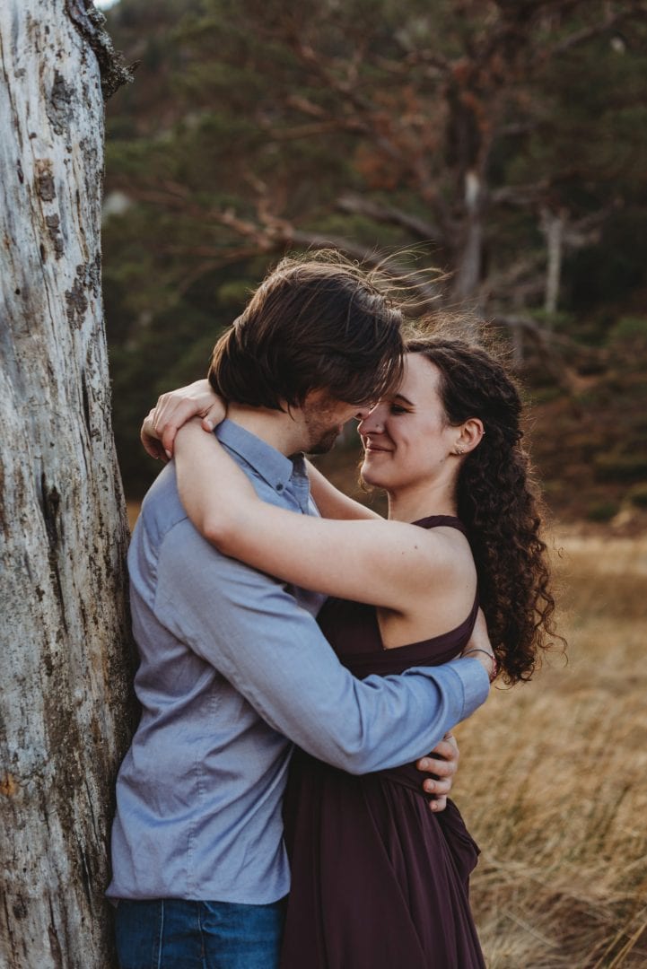 Happy couple by tree at session in the Cairngorms, Scottish Highlands