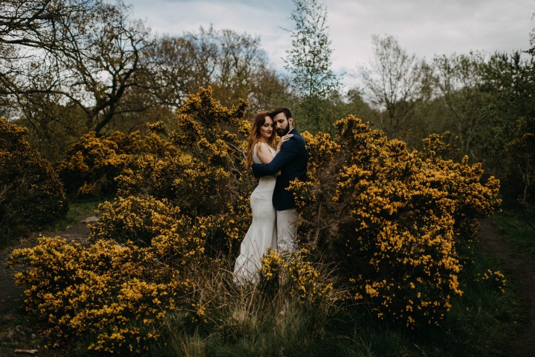 Couples shoot in nature Scotland by trees and gorse bushes. Lena Sabala and Patrick Zaarour on Mark Pacura workshop.