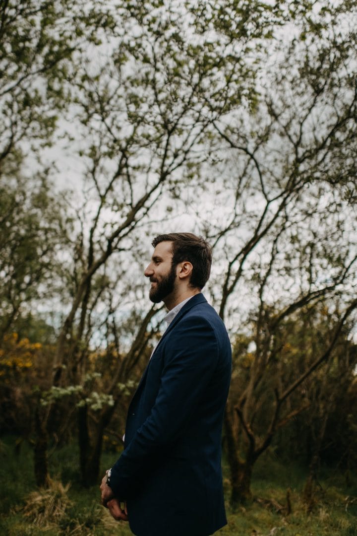 Groom in nature Scotland by trees. Lena Sabala and Patrick Zaarour on Mark Pacura workshop.
