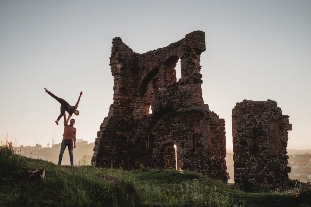 Acro balance couple during couples connection photoshoot in Edinburgh - Holyrood Park - St Anthonys Chapel