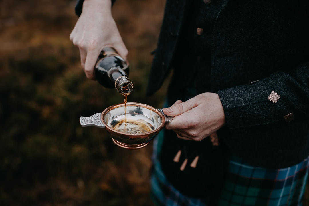 Pouring quaich with lindisfarne mead in Glencoe - Scottish tradition
