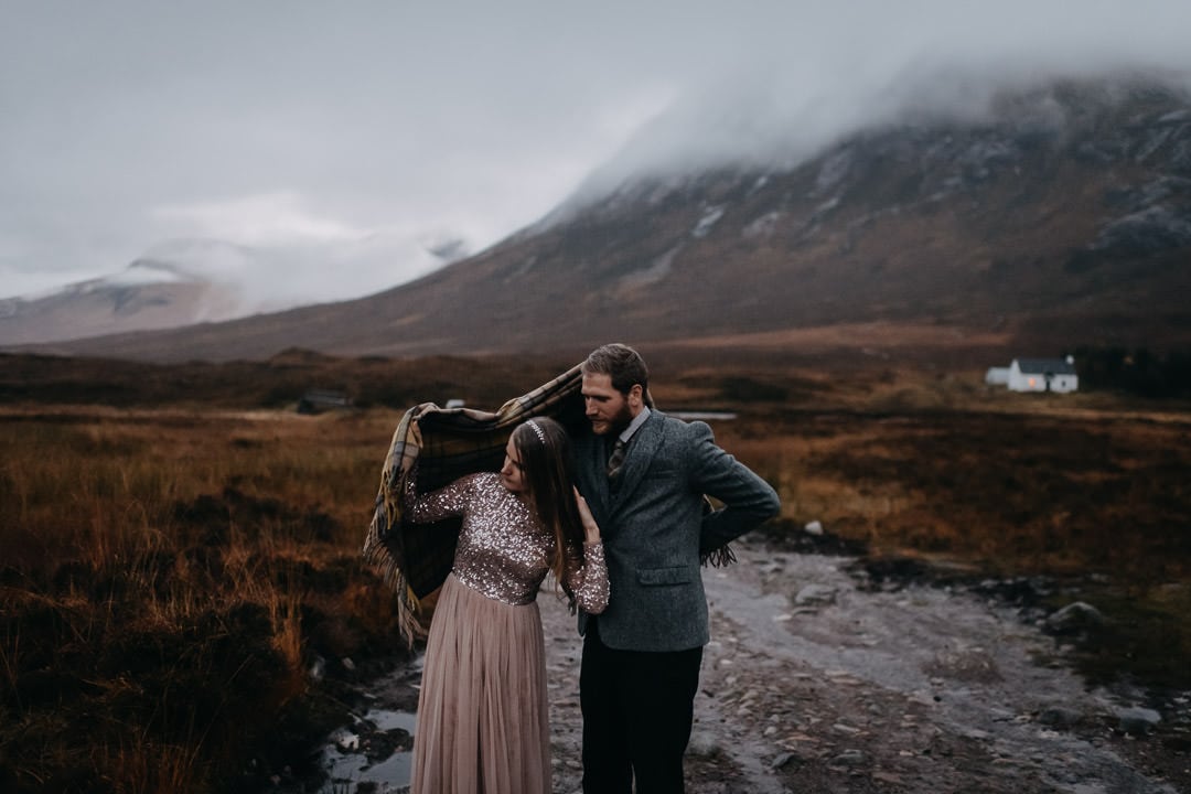 Elopement couple adventure session with tartan blanket at foggy Glencoe