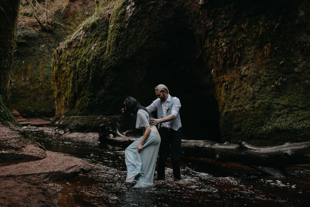 Adventurous elopement couple walking in The Devil's Pulpit, Glen Finnick