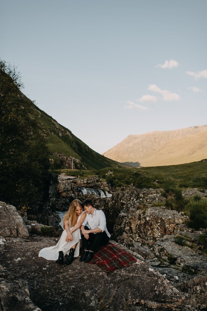 Wedding couple sitting on Tartan Blanket Co blanket during Glen Etive elopement