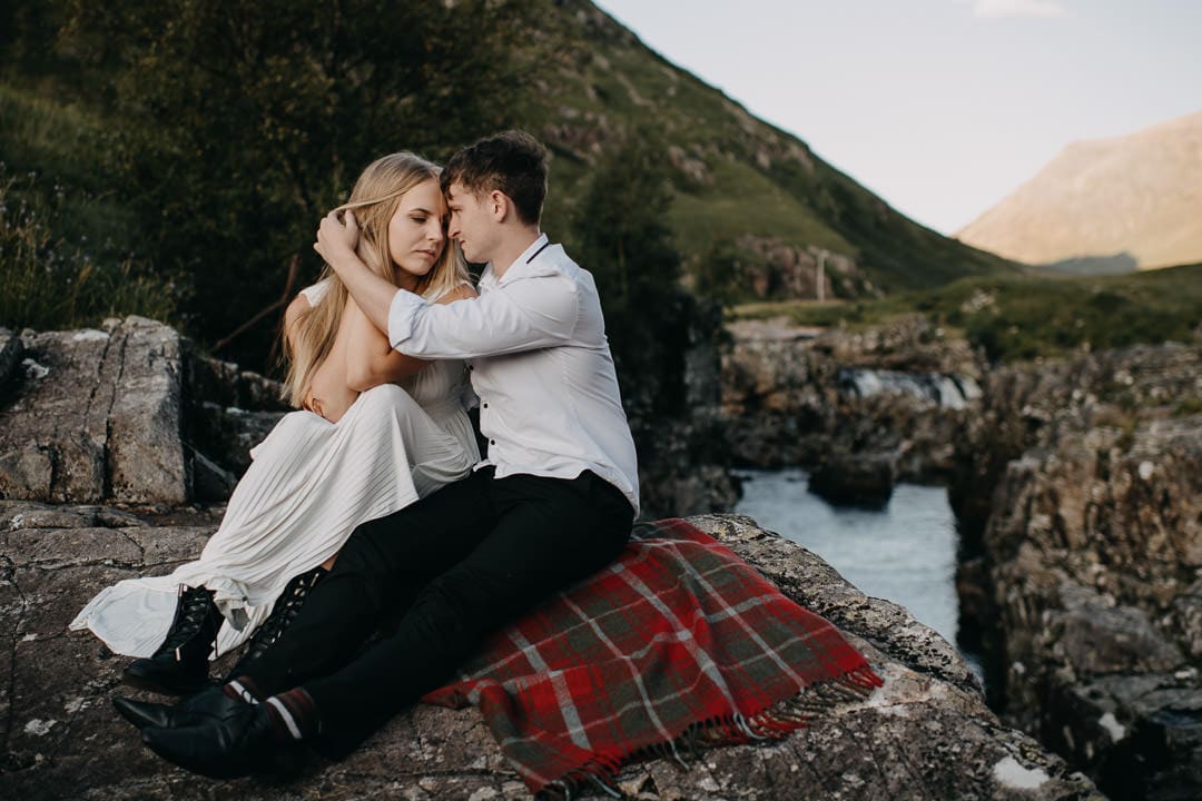 Wedding couple sitting on Tartan Blanket Co blanket during Glen Etive elopement