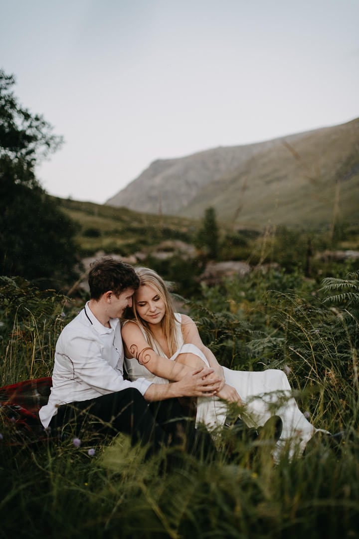 Wedding couple sitting on Tartan Blanket Co blanket during Glen Etive elopement