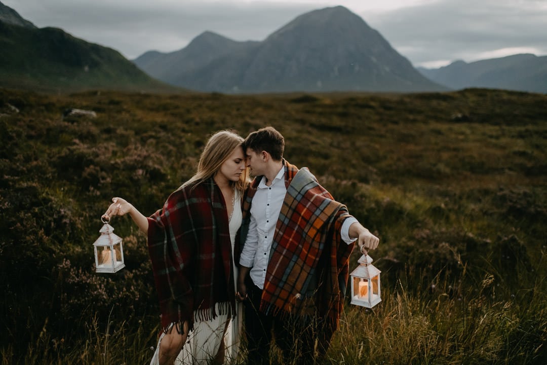 Wedding couple during Scottish elopement holding lanterns during dusk hour