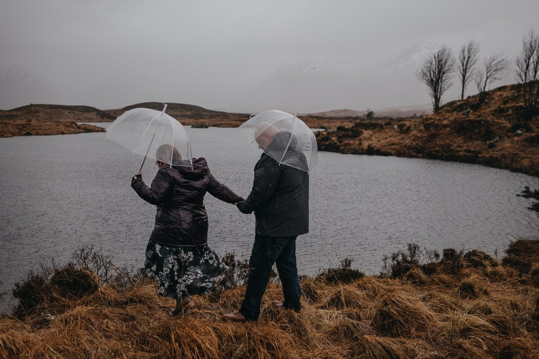 Walking through the moors on a winter rainy couples session in Glencoe