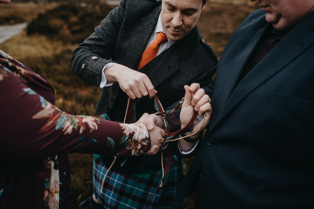 Romantic handfasting cord tying the knot in Glencoe during wedding anniversary photoshoot in Scottish Highlands