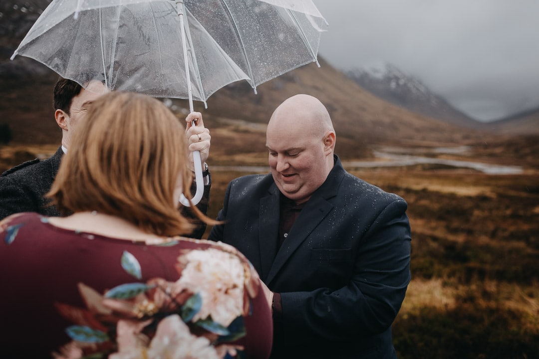 Romantic handfasting in Glencoe during wet wedding anniversary photoshoot in Scottish Highlands