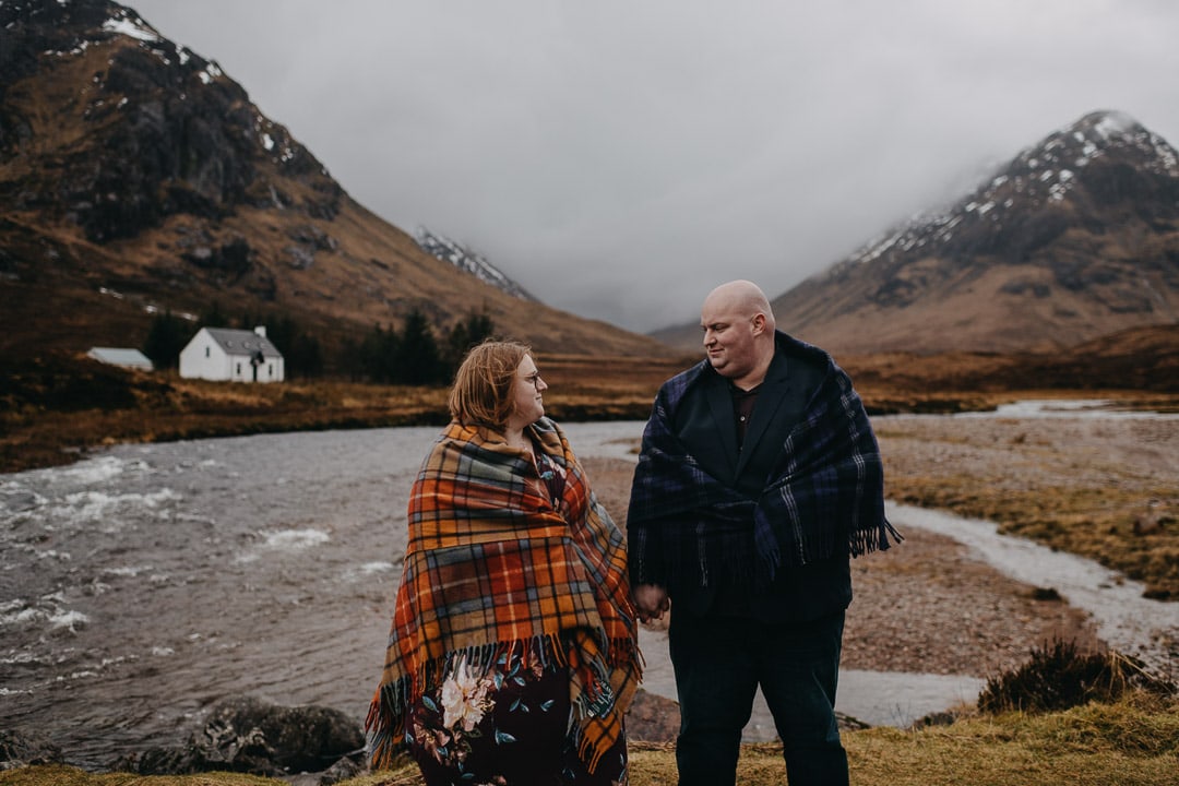 Buachaille Etive Mhor in Glencoe on romantic couples adventure session wearing a tartan blanket