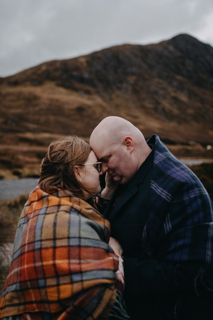 Exploring Buachaille Etive Mhor in Glencoe on couples adventure session wearing a Tartan blanket
