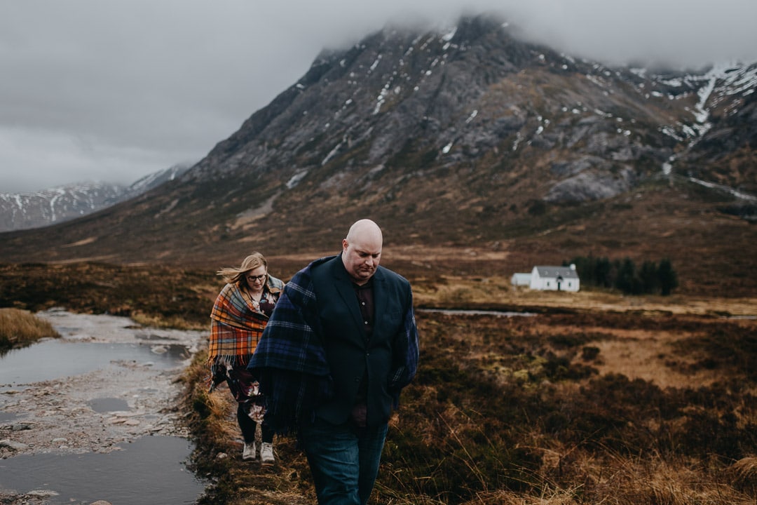 Exploring Buachaille Etive Mhor in Glencoe on couples adventure session wearing a Tartan blanket