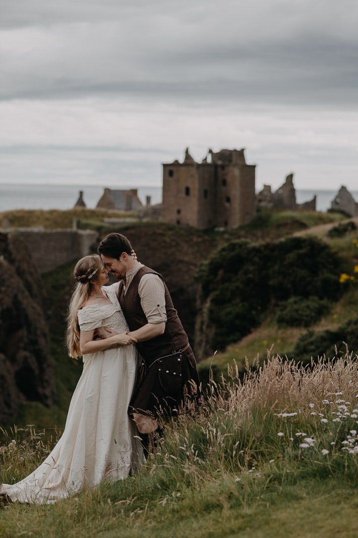 Dunnottar Castle elopement and proposal location in Scotland - couple hugging in front of Castle