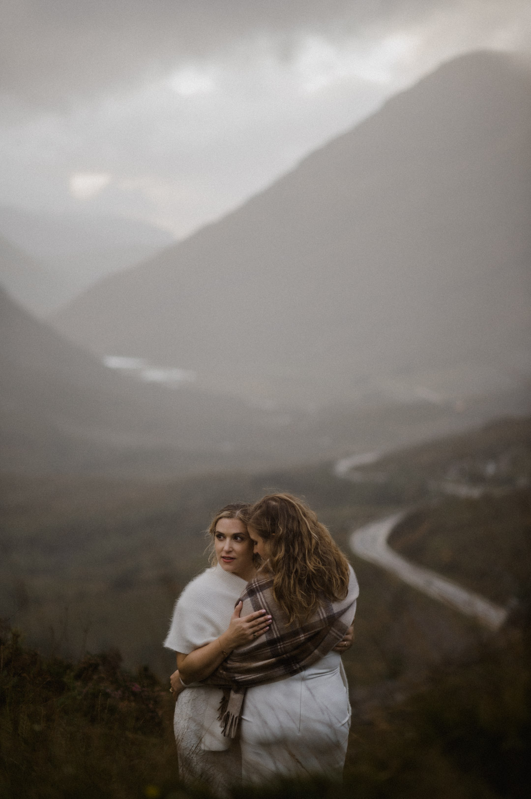 Glencoe elopement with stormy sunset - two brides cuddling