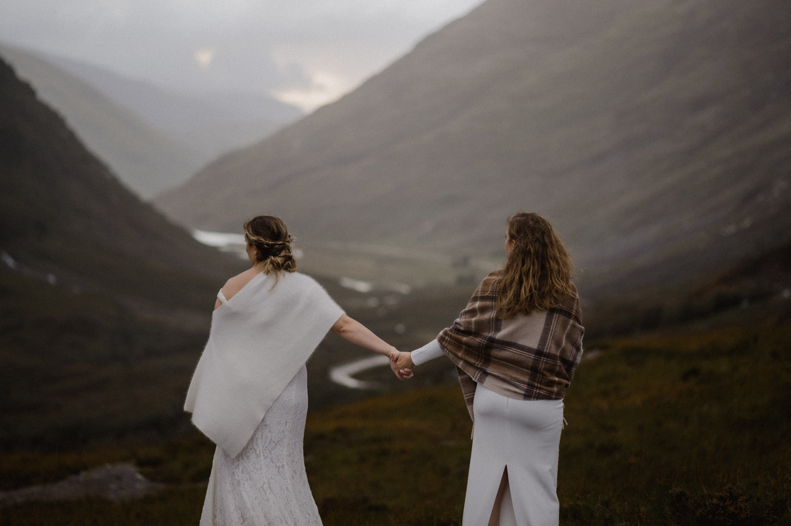 Glencoe elopement with stormy sunset - two brides holding hands