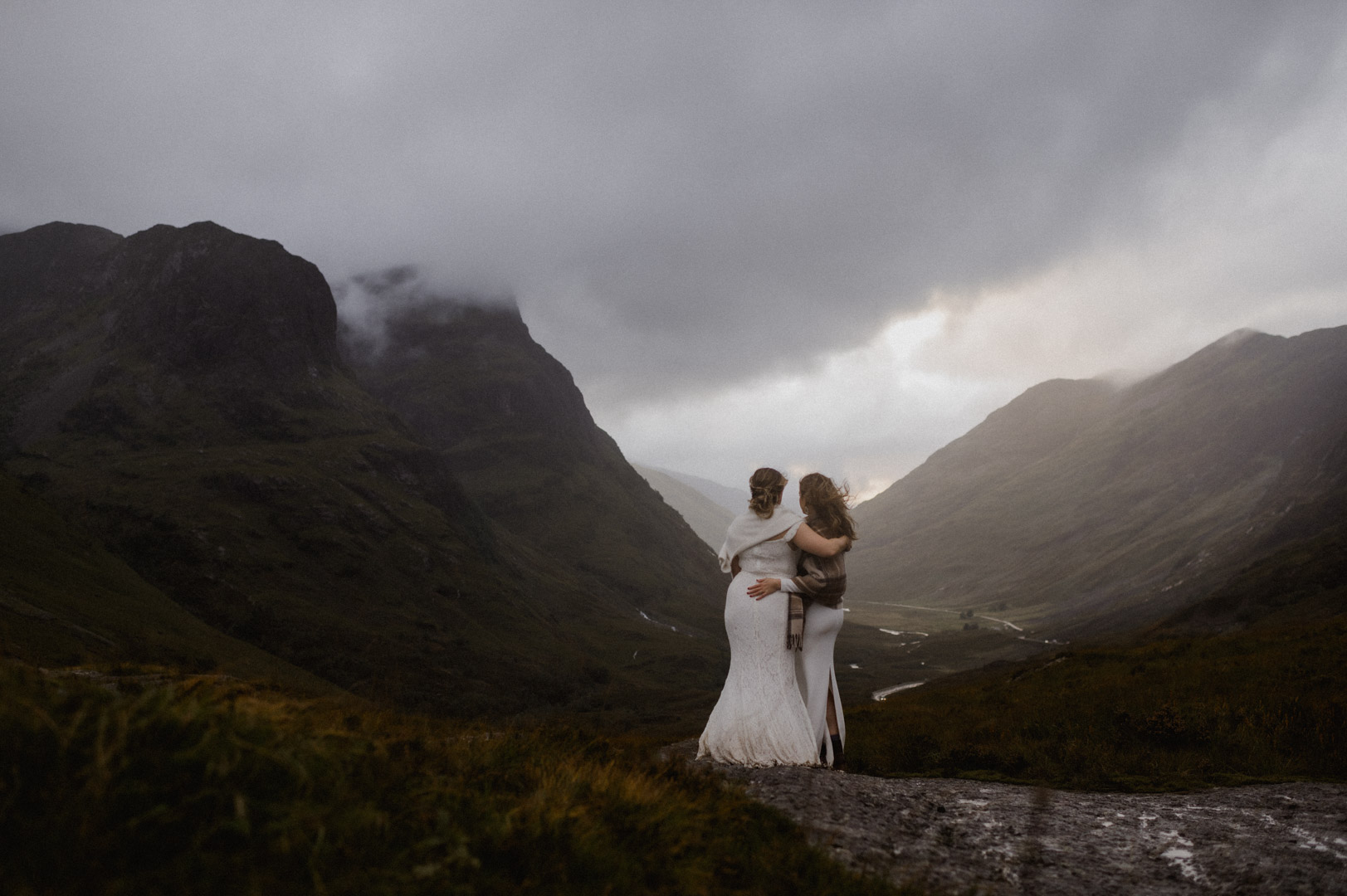 Glencoe elopement with stormy sunset - two brides cuddling