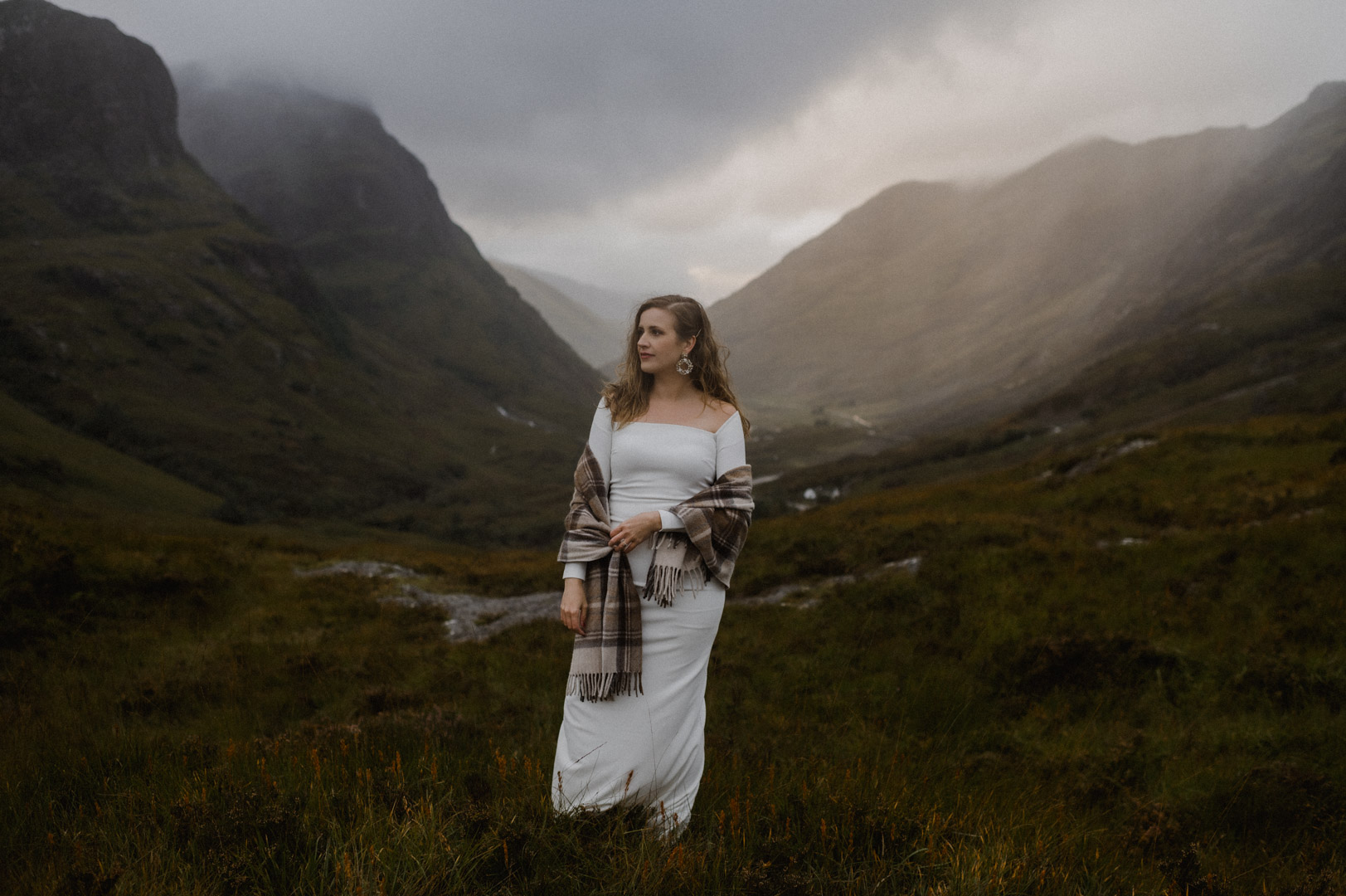 Bride standing in Glencoe with stormy sunset