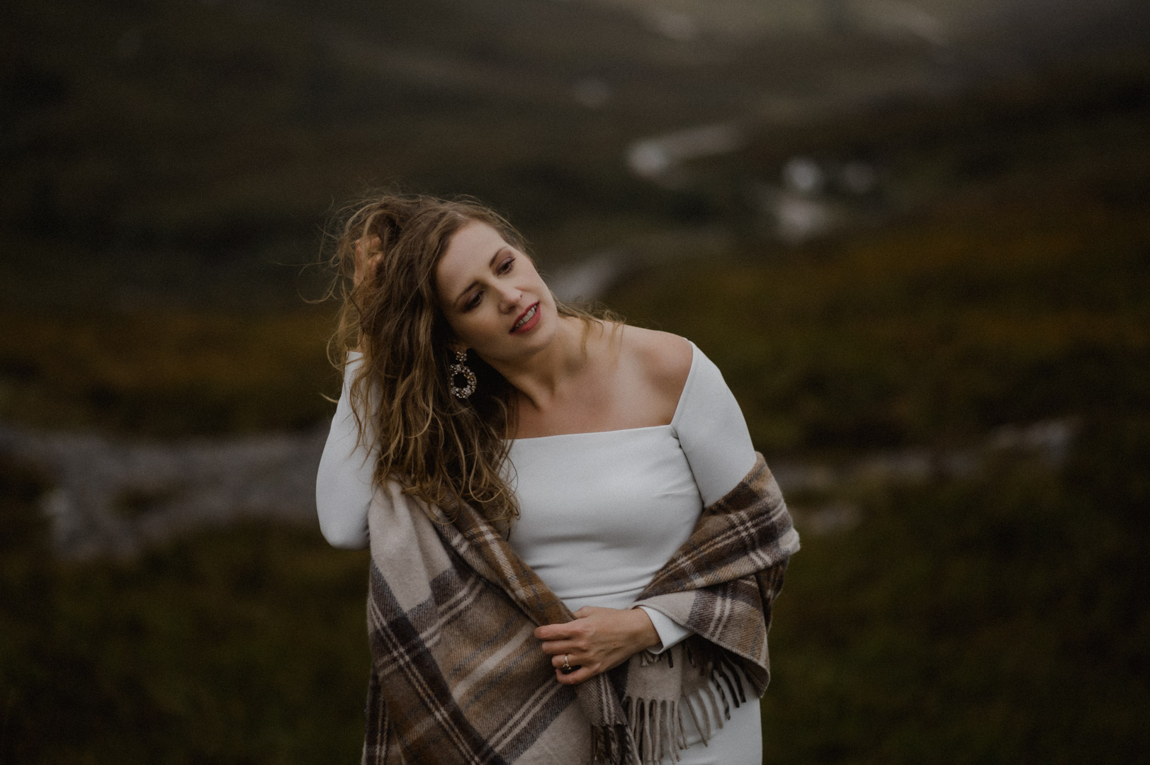 Bride standing in Glencoe with stormy sunset
