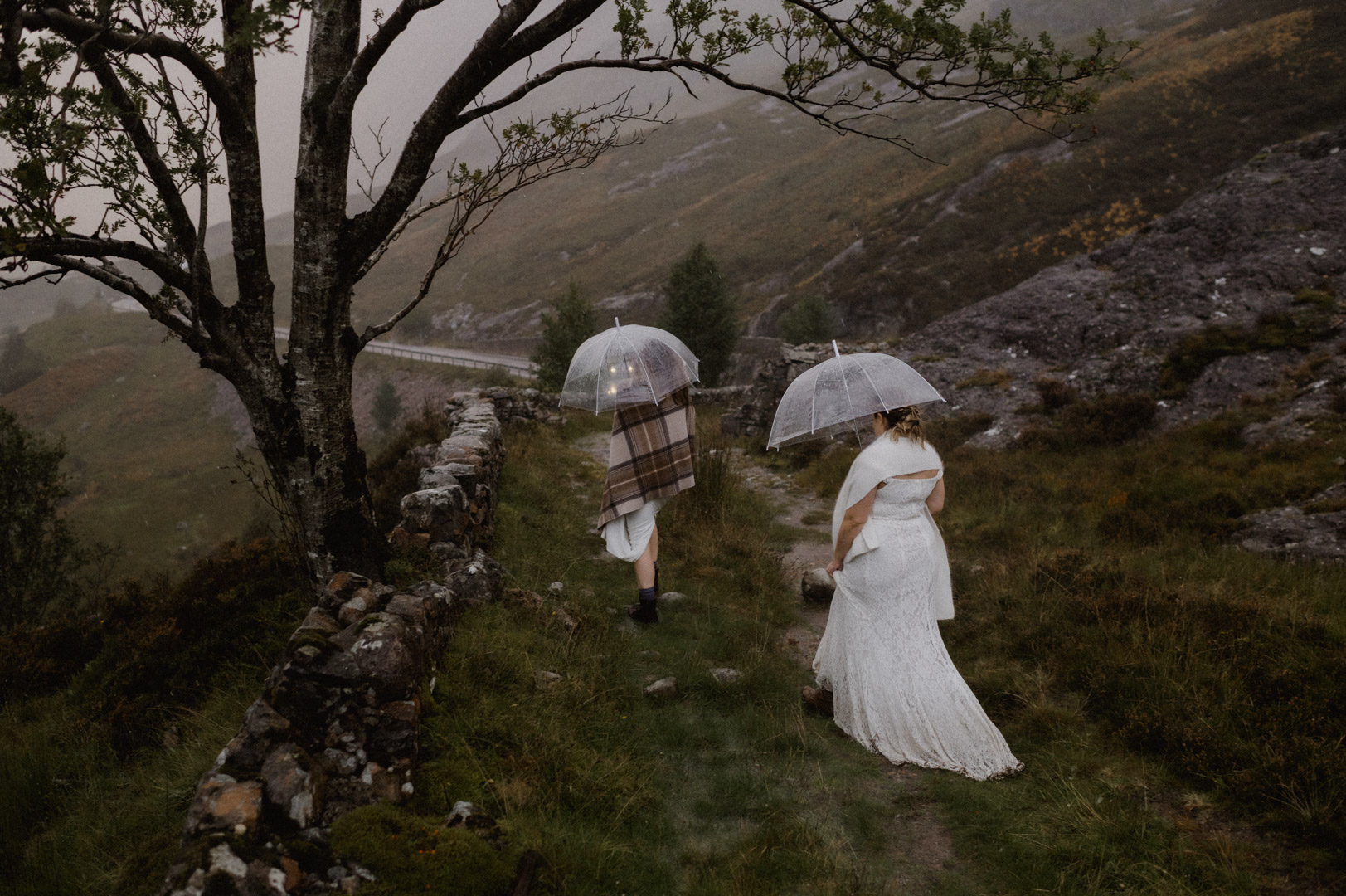 Walking to car in Glencoe during stormy sunset - same-sex couple