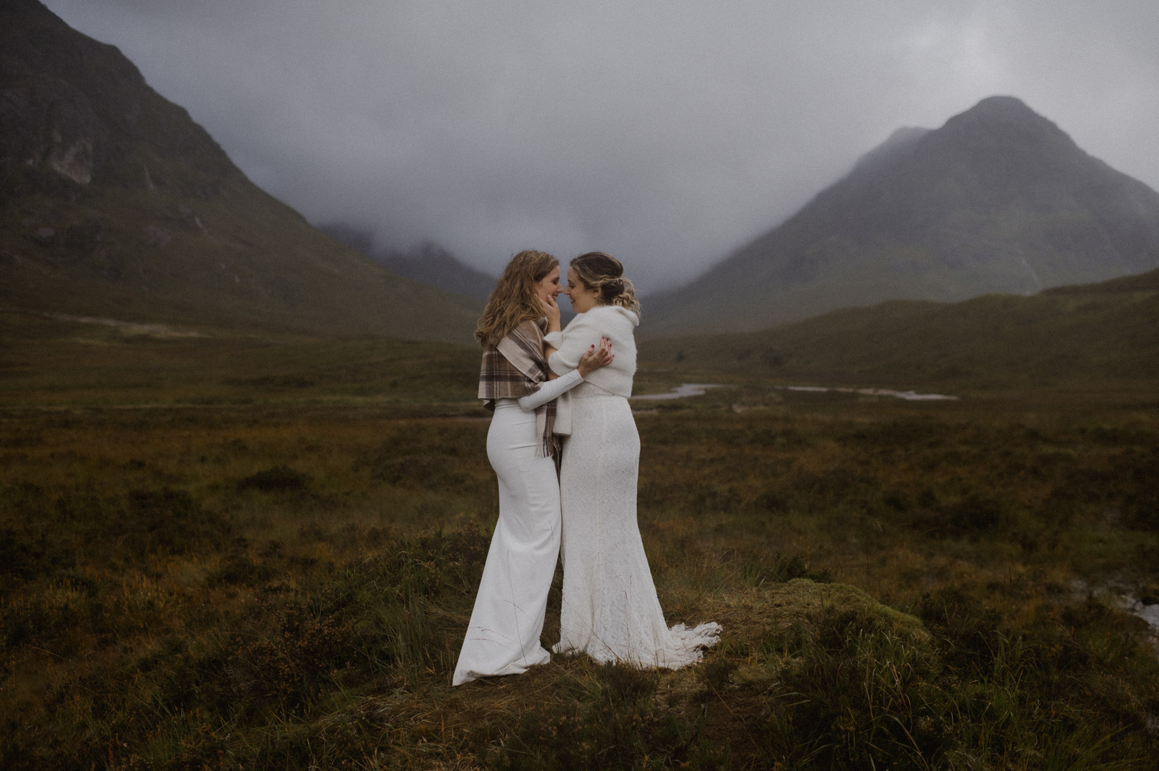Lesbian couple exploring Glencoe in stormy Autumn