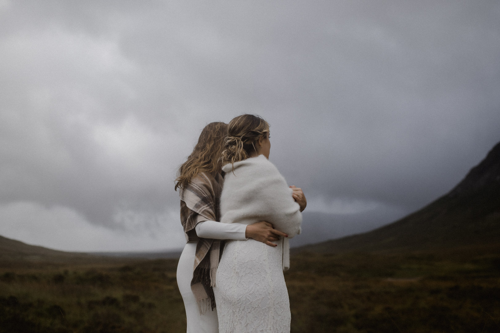 Lesbian couple exploring Glencoe in stormy Autumn