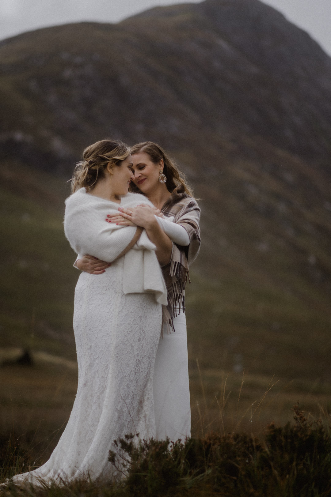 Lesbian couple exploring Glencoe in stormy Autumn