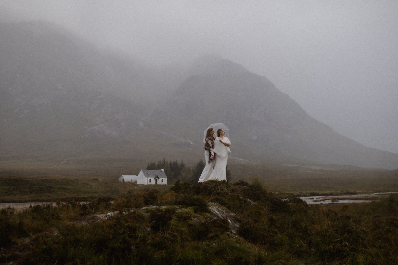 Lesbian couple exploring Glencoe in stormy Autumn