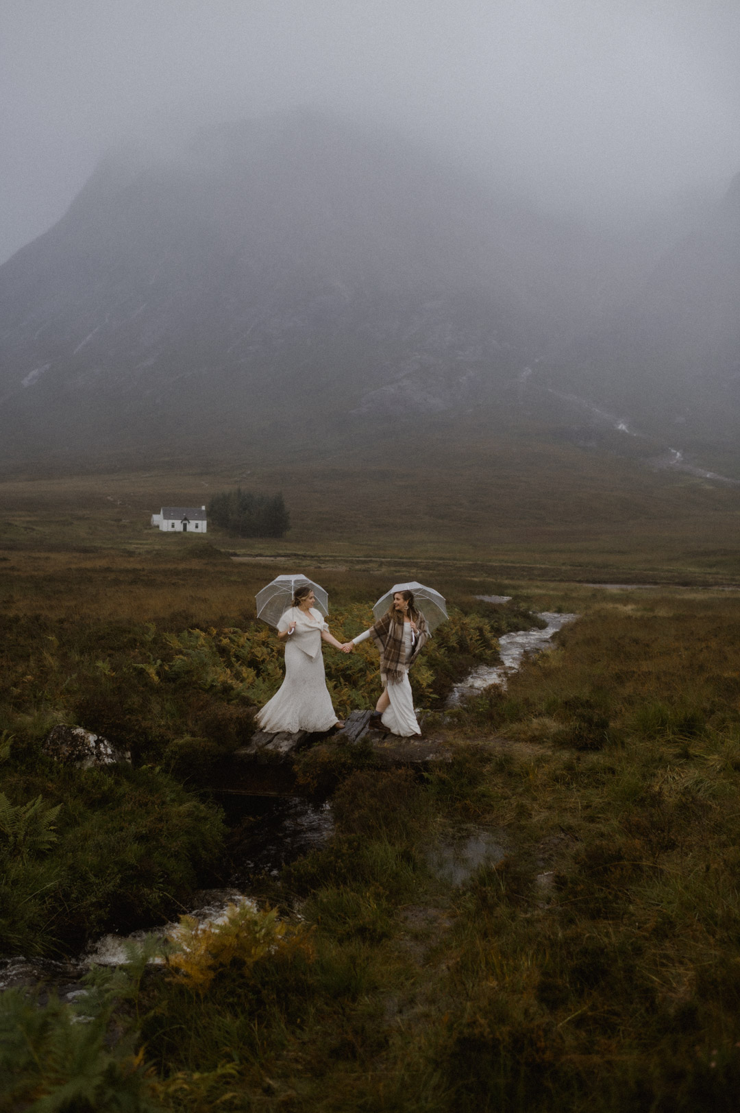 Lesbian couple exploring Glencoe Laganbargh Hut in stormy Autumn