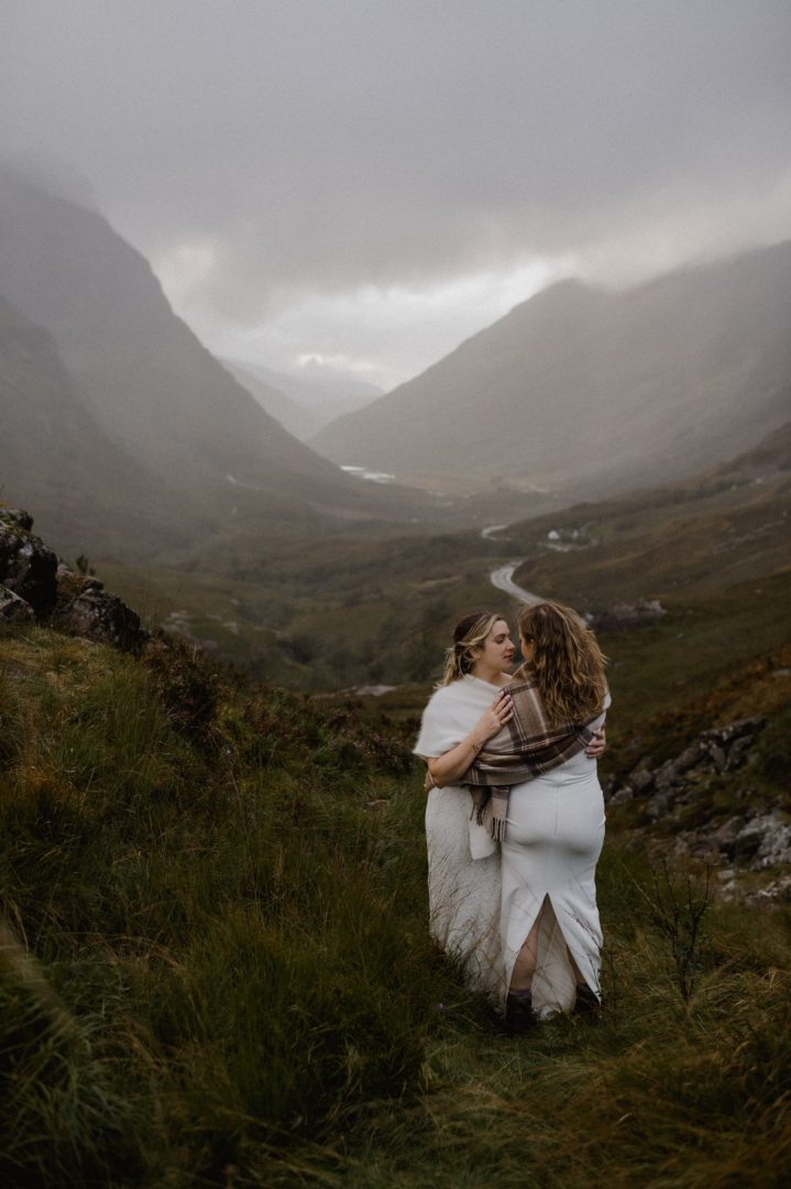 Glencoe elopement with stormy sunset - two brides cuddling