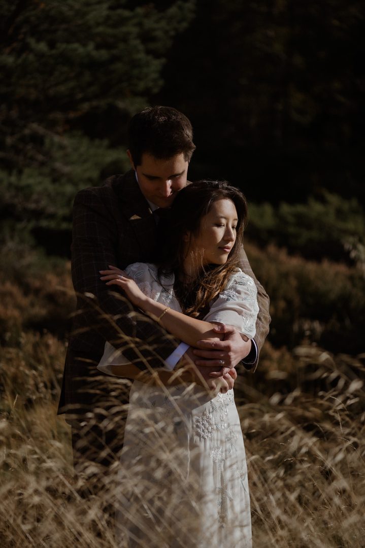 Couple cuddling Loch Morlich autumnal cairngorms elopement