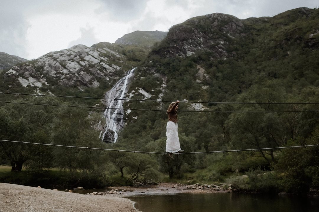 Adventurous bride walks across a tight-rope bridge to reach waterfall in Scottish elopement