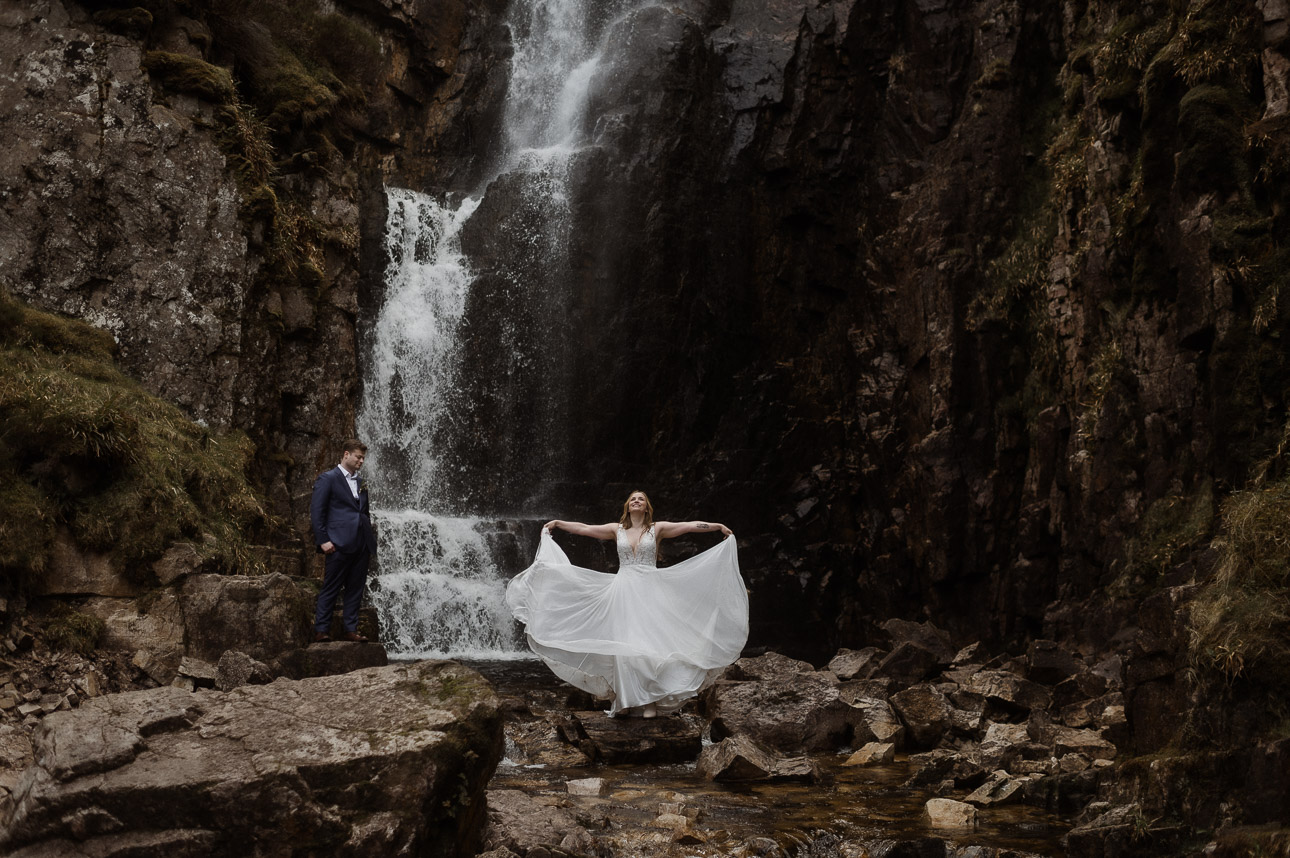 Elopement couple revelling in the beauty of one of Scotland's most majestic waterfall