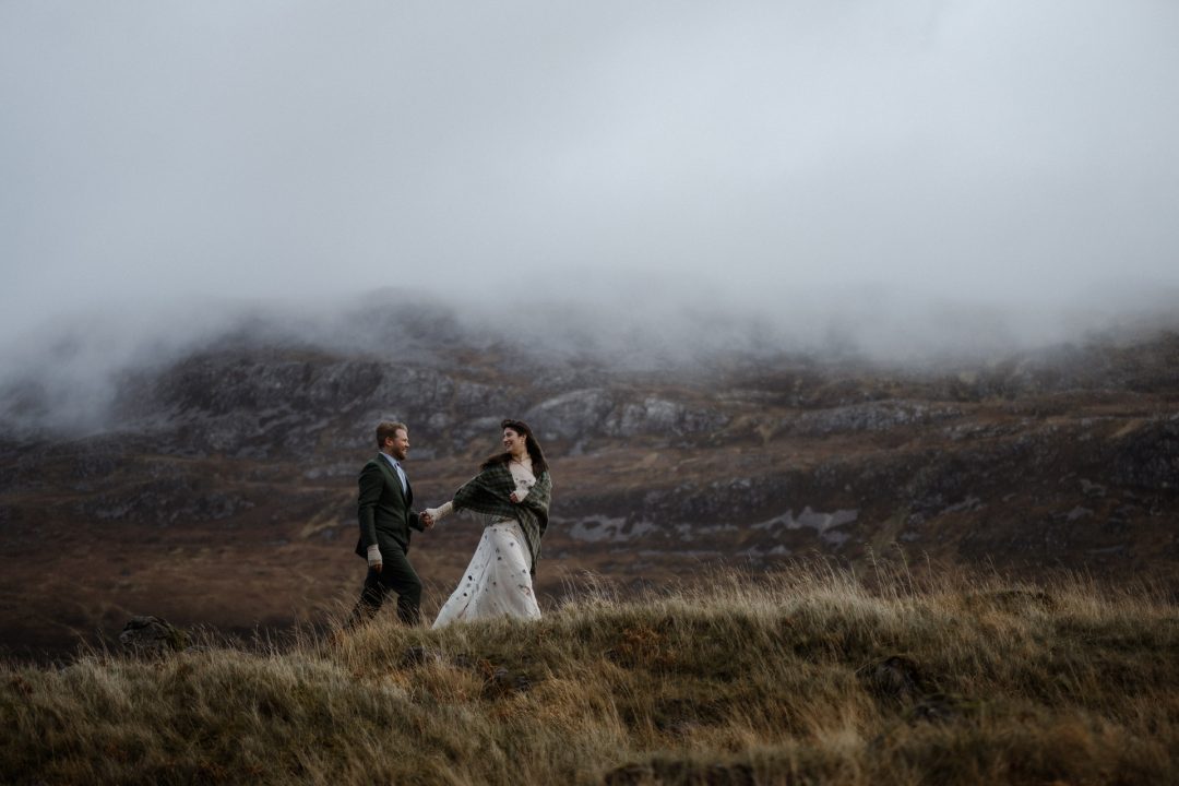 Couple walking on a misty mountain during their Wild Mythical Assynt Elopement in Scotland