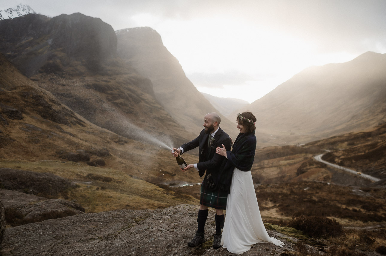 Couple spraying champagne during Spring elopement in Scotland