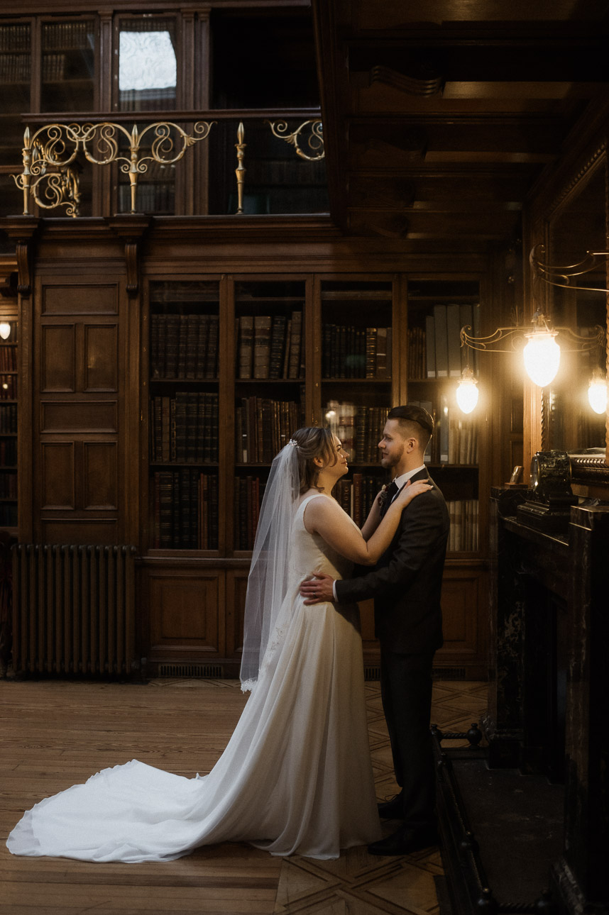 Couple cuddling in dark academia library in Edinburgh during elopement - Royal College of Physicians